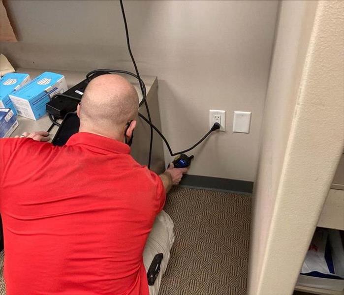 Man measuring moisture levels in a wall.